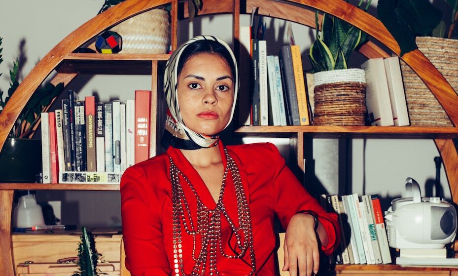 stylish ethnic woman in trendy outfit in living room